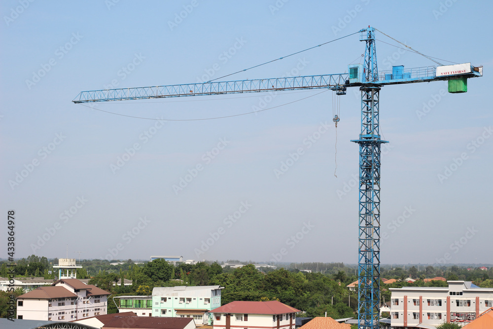 The construction crane on against blue sky.