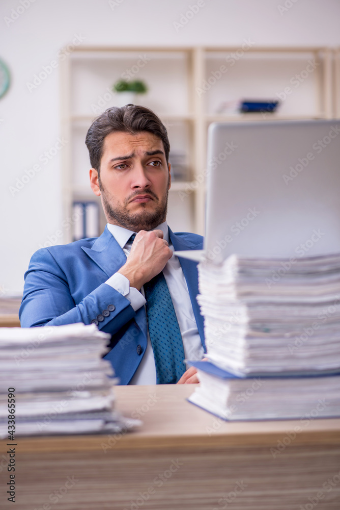 Young businessman employee and too much work in the office Young businessman employee and too much work in the office