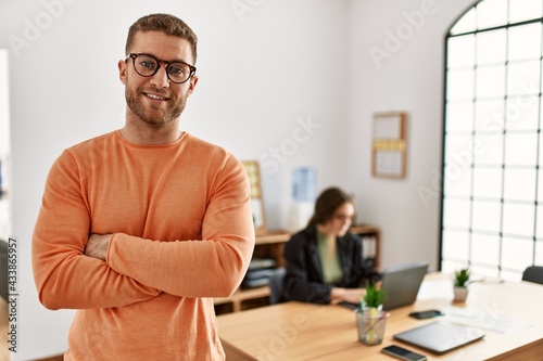 Businessman smiling happy with arms crossed gesture standing at the office.