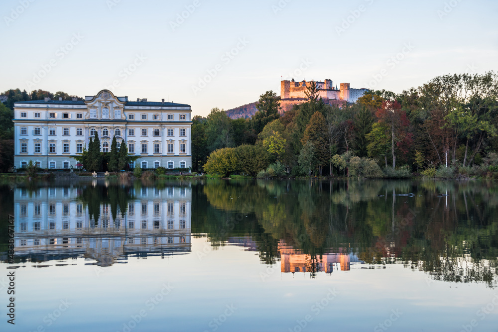 Beautiful sunset colors in Leopoldskroner Weiher Lake with Leopoldskron Palace and Hohensalzburg Fortress in the background - Salzburg, Austria 