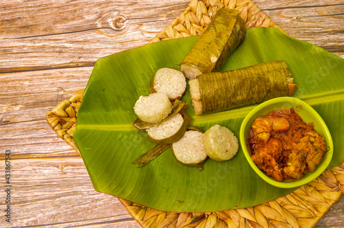Malay traditional food called as Lemang and chicken rendang served during Eid Mubarak. Glutinousrice is wrapped with banana leaf encased in bamboo culm and cooked in open fire. photo