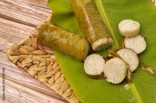 Malay traditional food called as Lemang served during Eid Mubarak. Glutinous rice is wrapped with banana leaf encased in bamboo clum and cooked in open fire. photo