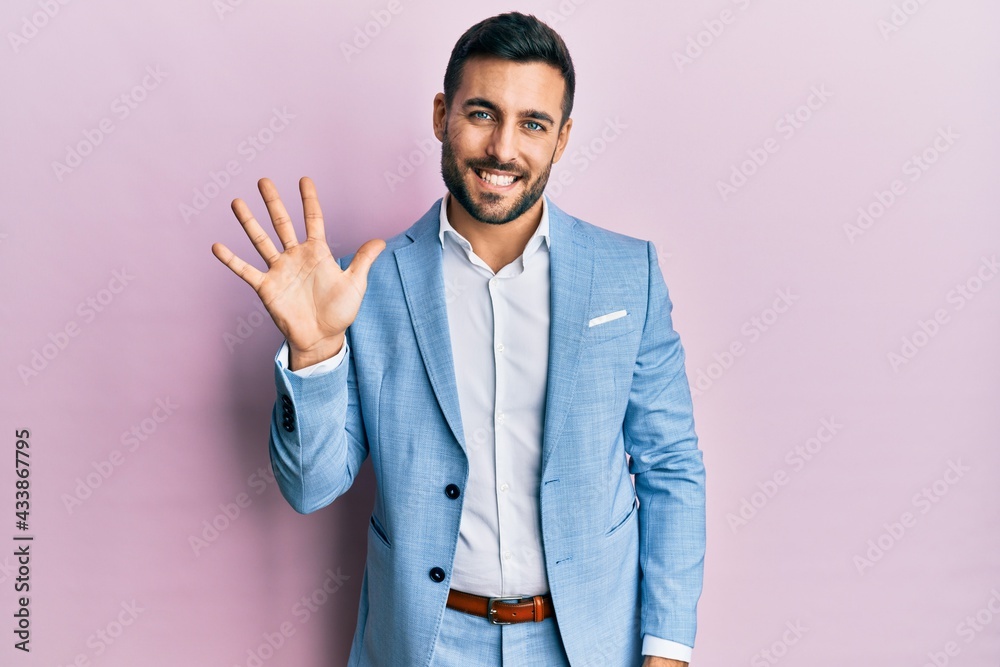 Young hispanic businessman wearing business jacket showing and pointing up with fingers number five while smiling confident and happy. Young hispanic businessman wearing business jacket showing and pointing up with fingers number five while smiling confident and happy.