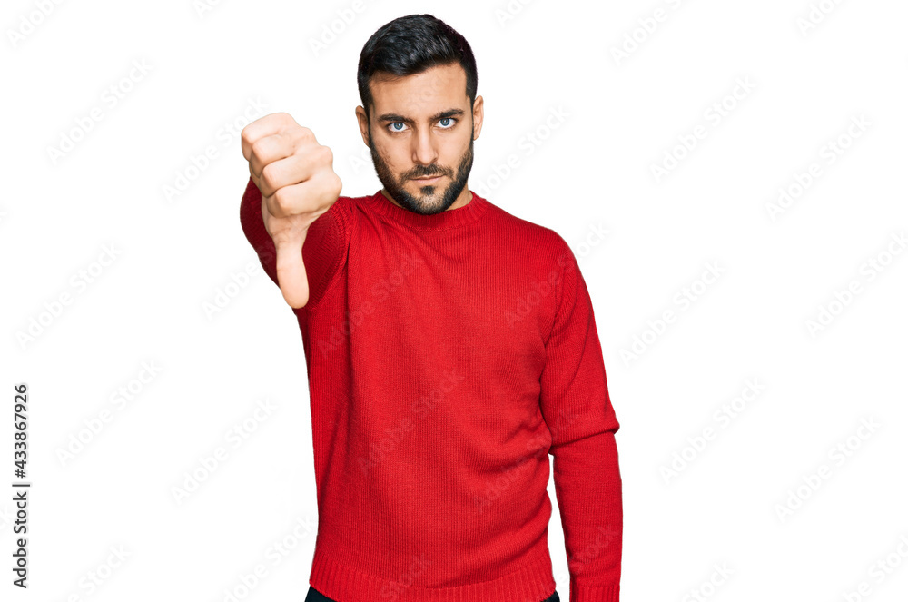 Young hispanic man wearing casual clothes looking unhappy and angry showing rejection and negative with thumbs down gesture. bad expression. Young hispanic man wearing casual clothes looking unhappy and angry showing rejection and negative with thumbs down gesture. bad expression.