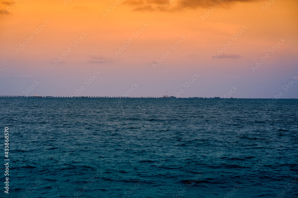 Obraz premium The picture of the bridge stretching out into the sea with the atmosphere in the evening. At Phayun Beach, Rayong, Thailand