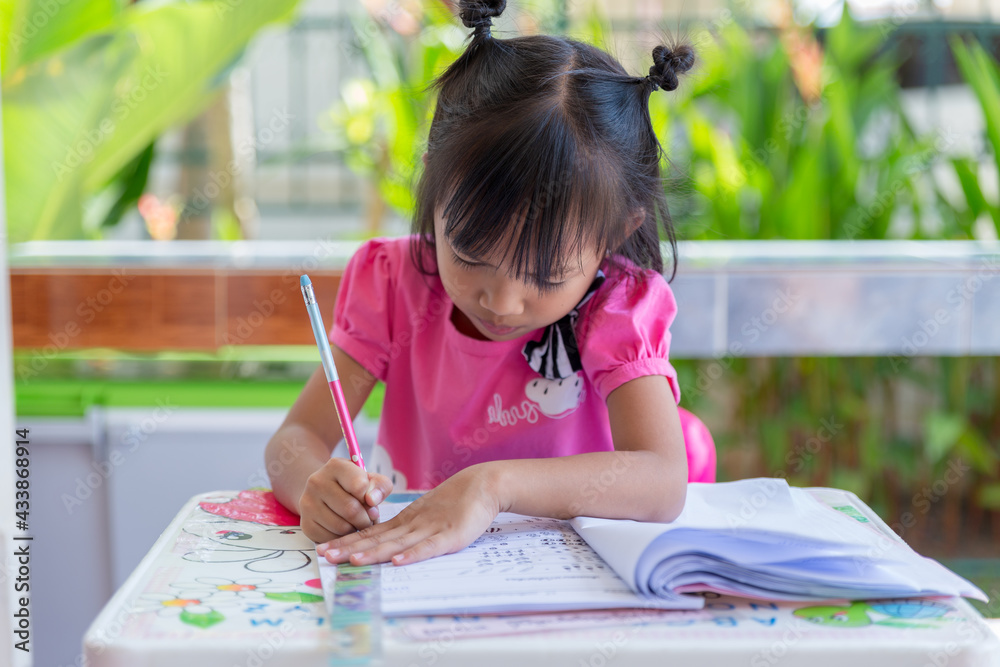 Asian girls enjoy homework. Asian girl does homework in the classroom. girl kid activity in classroom. Asian girls enjoy homework. Asian girl does homework in the classroom. girl kid activity in classroom.