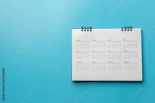 Calendar on solid blue background with copy space, business meeting schedule, travel planning or project milestone and reminder concept.