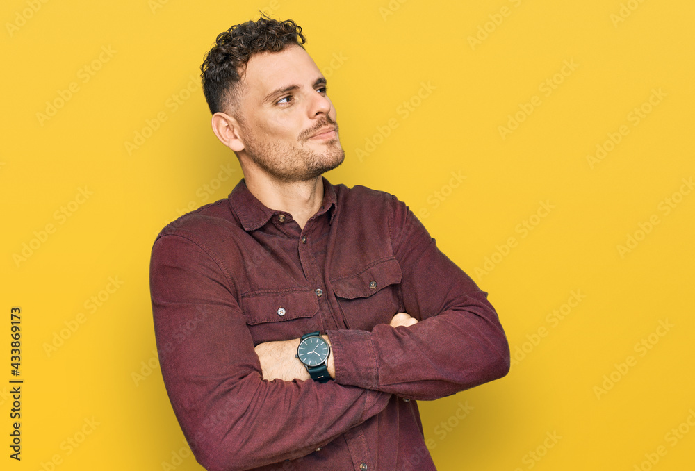 Young hispanic man wearing casual clothes looking to the side with arms crossed convinced and confident Young hispanic man wearing casual clothes looking to the side with arms crossed convinced and confident