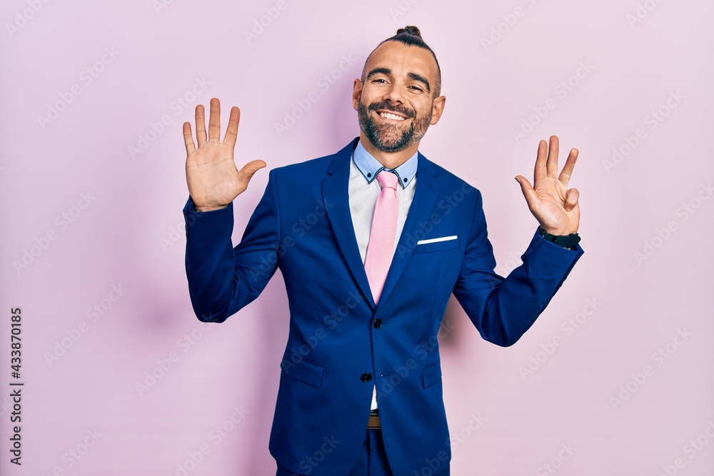 Young hispanic man wearing business suit and tie showing and pointing up with fingers number nine while smiling confident and happy. Young hispanic man wearing business suit and tie showing and pointing up with fingers number nine while smiling confident and happy.