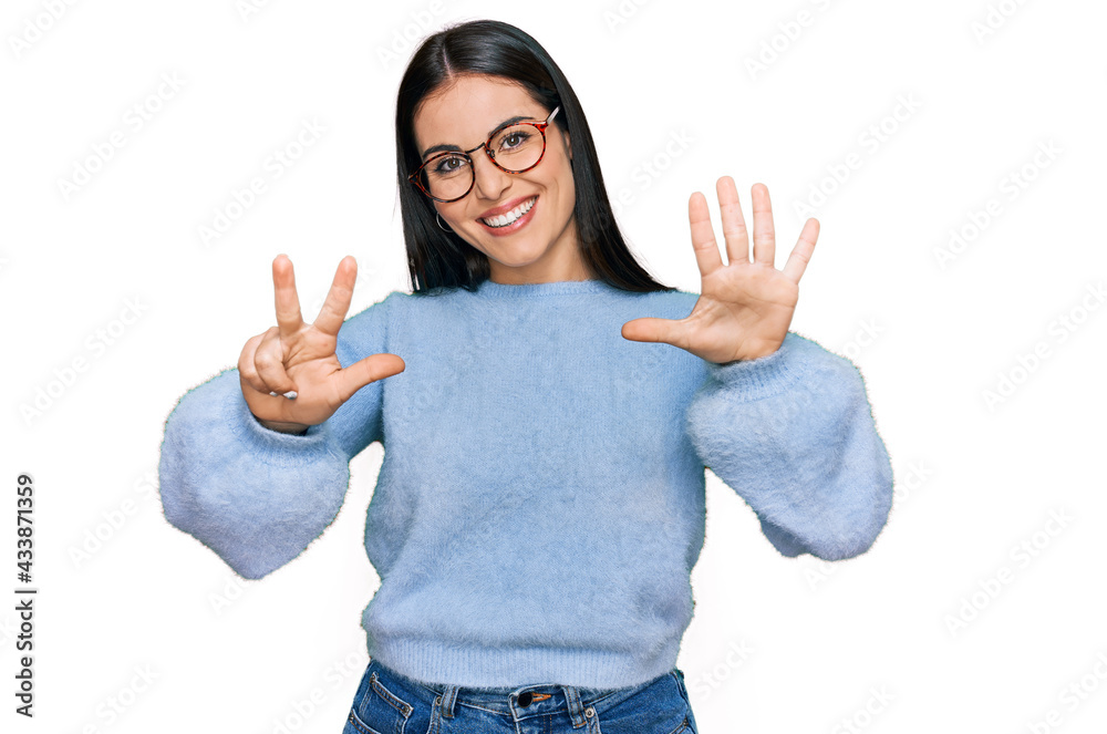 Young hispanic woman wearing casual clothes and glasses showing and pointing up with fingers number eight while smiling confident and happy. Young hispanic woman wearing casual clothes and glasses showing and pointing up with fingers number eight while smiling confident and happy.