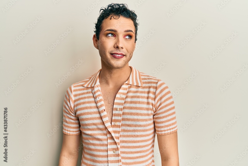 Handsome man wearing make up wearing casual t shirt looking away to side with smile on face, natural expression. laughing confident. Handsome man wearing make up wearing casual t shirt looking away to side with smile on face, natural expression. laughing confident.
