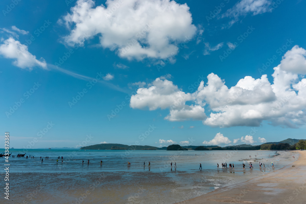 Landscape of sea sand beach under blue sky and white fluffy clouds