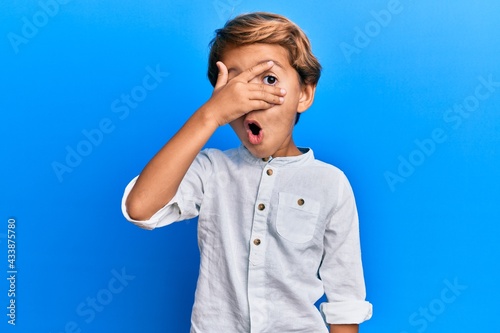 Canvas Print Adorable latin kid wearing casual clothes peeking in shock covering face and eye