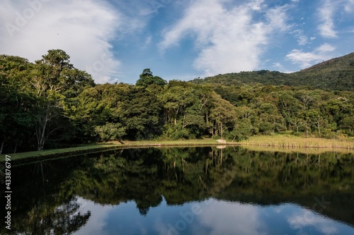 Panorama of natural landscape with lake in the mountain of Pedra Grande. Water mirror, local vegetation, mountain and blue sky with clouds.. Atibaia, Brazil.