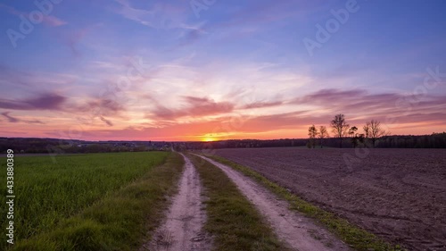 4k timelapse with dramatic sunset sky over spring field and road