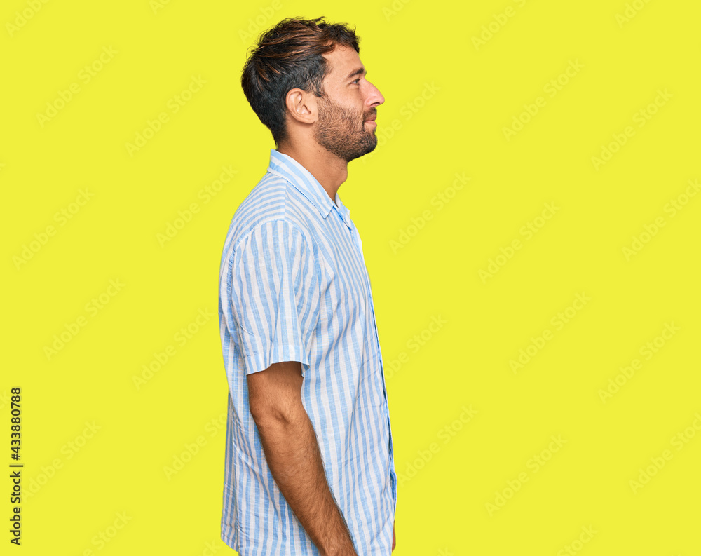Handsome young man with beard wearing casual fresh shirt looking to side, relax profile pose with natural face with confident smile. Handsome young man with beard wearing casual fresh shirt looking to side, relax profile pose with natural face with confident smile.