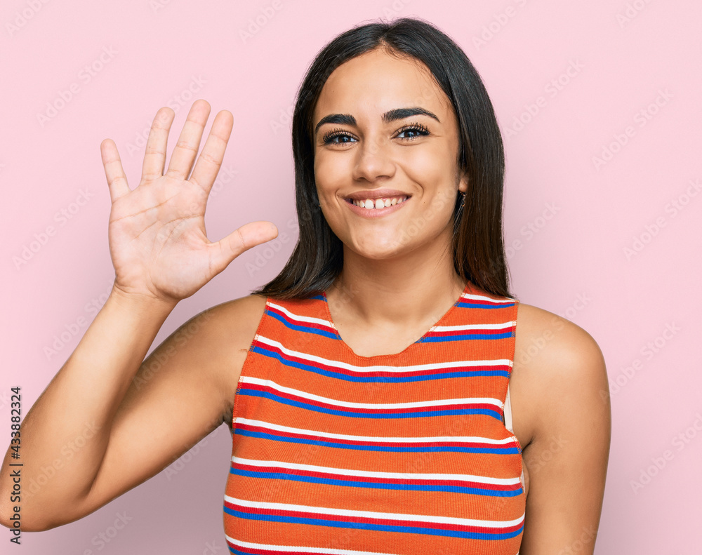 Young brunette woman wearing casual clothes showing and pointing up with fingers number five while smiling confident and happy.