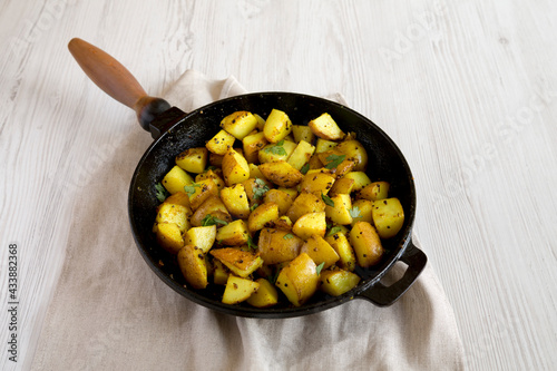 Homemade Roasted Potatoes with Mustard Seeds in a cast-iron pan, low angle view.