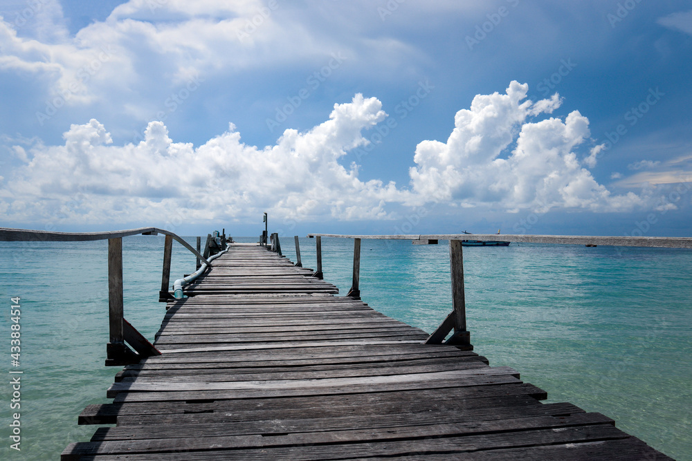Naklejka premium Koh Samed Island view, beautiful natural scene of tropical summer sea, wooden bridge leading over crystal clear water sea and cloudy blue sky.