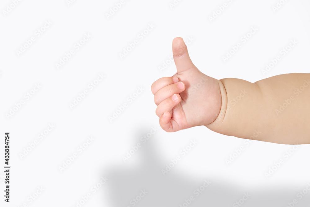 Photo Stock 白背景で親指を立てグッドサインをする赤ちゃんの手 Adobe Stock