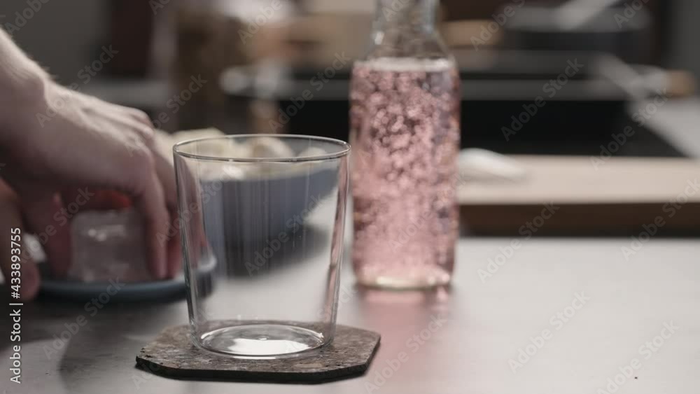 Slow motion man preparing pink drink with ice in tumbler glass Slow motion man preparing pink drink with ice in tumbler glass