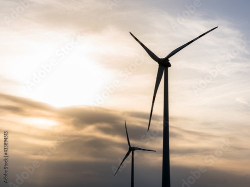 Wind turbines for green engergy at sunset with sky