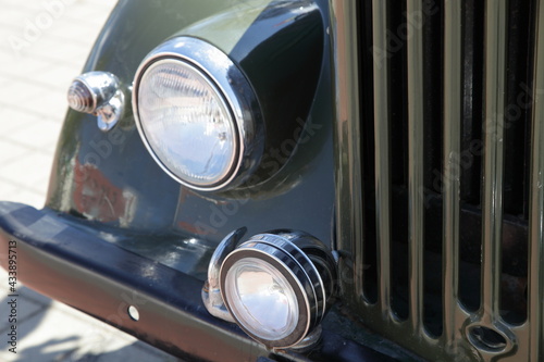 Vintage soviet military off road car headlight lamps, front bumper and radiator grille closeup