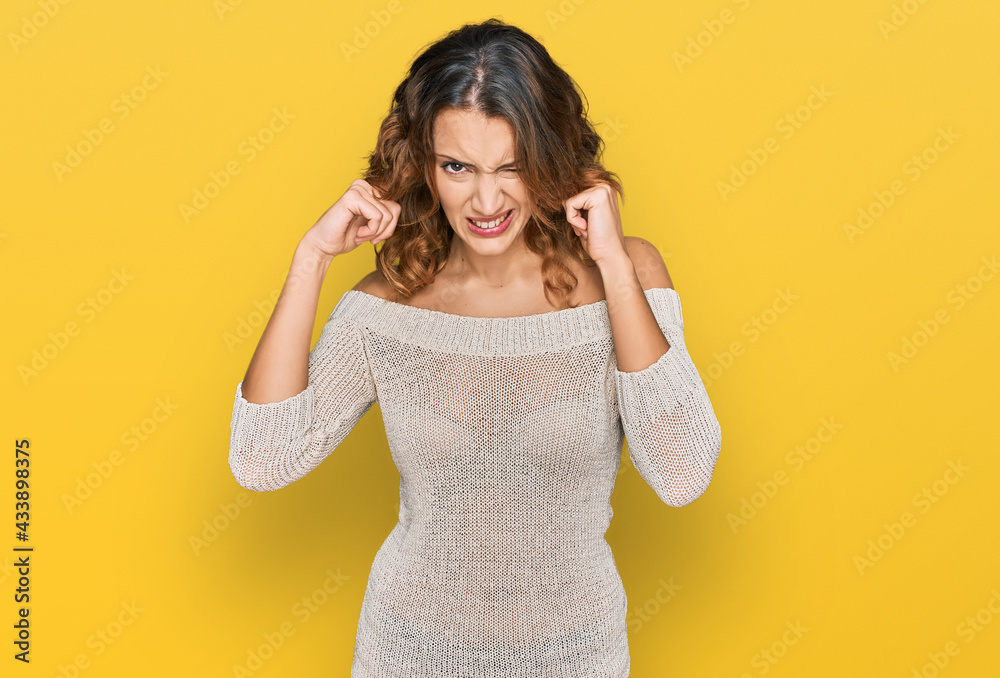 Beautiful young caucasian woman wearing casual clothes covering ears with fingers with annoyed expression for the noise of loud music. deaf concept. Beautiful young caucasian woman wearing casual clothes covering ears with fingers with annoyed expression for the noise of loud music. deaf concept.