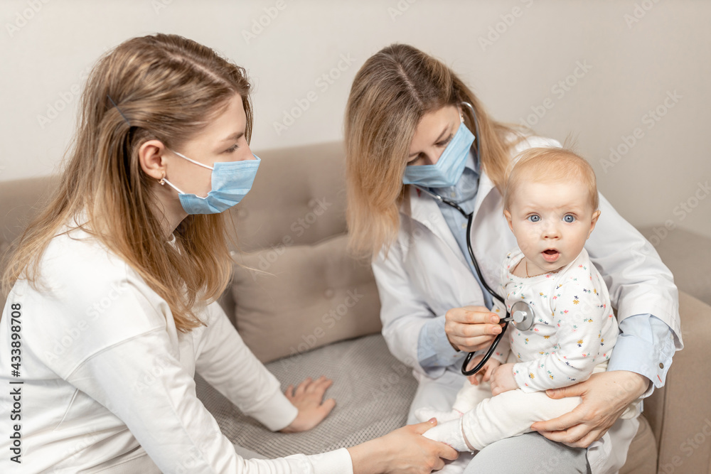 Female pediatrician exam baby girl patient, hold a stethoscope, check heart and lungs of little child. Woman doctor doing a month check up of cute toddler. Health care concept Female pediatrician exam baby girl patient, hold a stethoscope, check heart and lungs of little child. Woman doctor doing a month check up of cute toddler. Health care concept