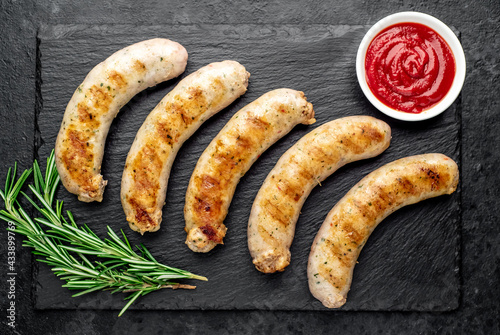 grilled sausages with spices on a stone background