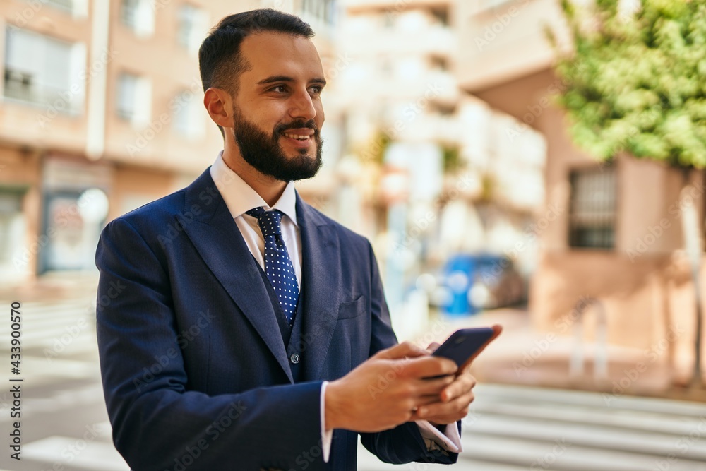 Young businessman smiling happy using smartphone at the city.