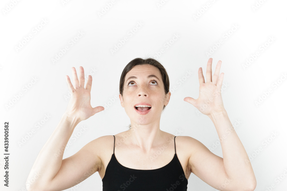 Young beautiful woman pointing up with fingers while thinking at white empty background Young beautiful woman pointing up with fingers while thinking at white empty background