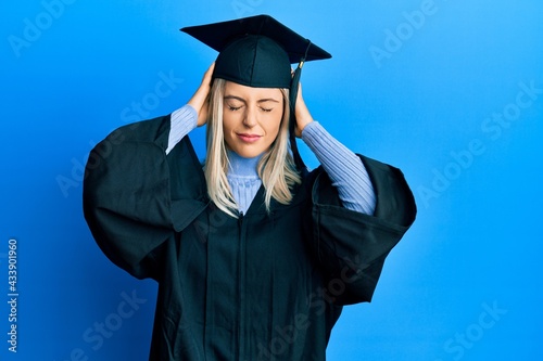Fotografie Beautiful blonde woman wearing graduation cap and ceremony robe suffering from headache desperate and stressed because pain and migraine