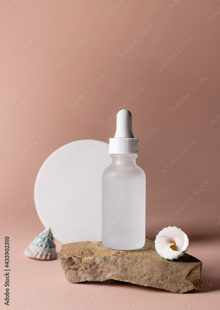 Glass bottle with cosmetic product on natural stone podium. minimal brand packaging mockup. beige background. vertical image