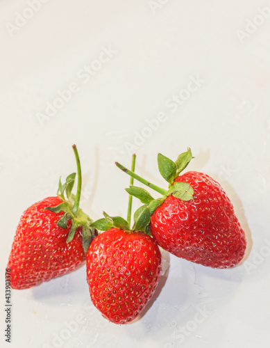 A lot of red ripe tasty strawberries lie on a white background