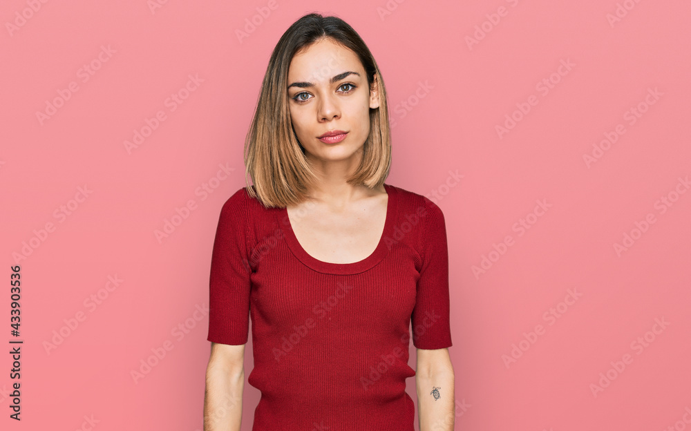 Young blonde girl wearing casual clothes relaxed with serious expression on face. simple and natural looking at the camera. Young blonde girl wearing casual clothes relaxed with serious expression on face. simple and natural looking at the camera.