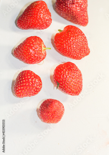 A lot of red ripe tasty strawberries lie on a white background