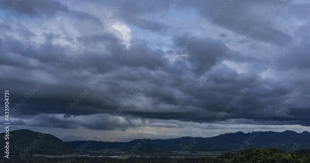 Time lapse of dark rainy clouds moving over hills and mountains in Slovenia. Dramatic sky with fast moving clouds. Static shot, wide angle Time lapse of dark rainy clouds moving over hills and mountains in Slovenia. Dramatic sky with fast moving clouds. Static shot, wide angle