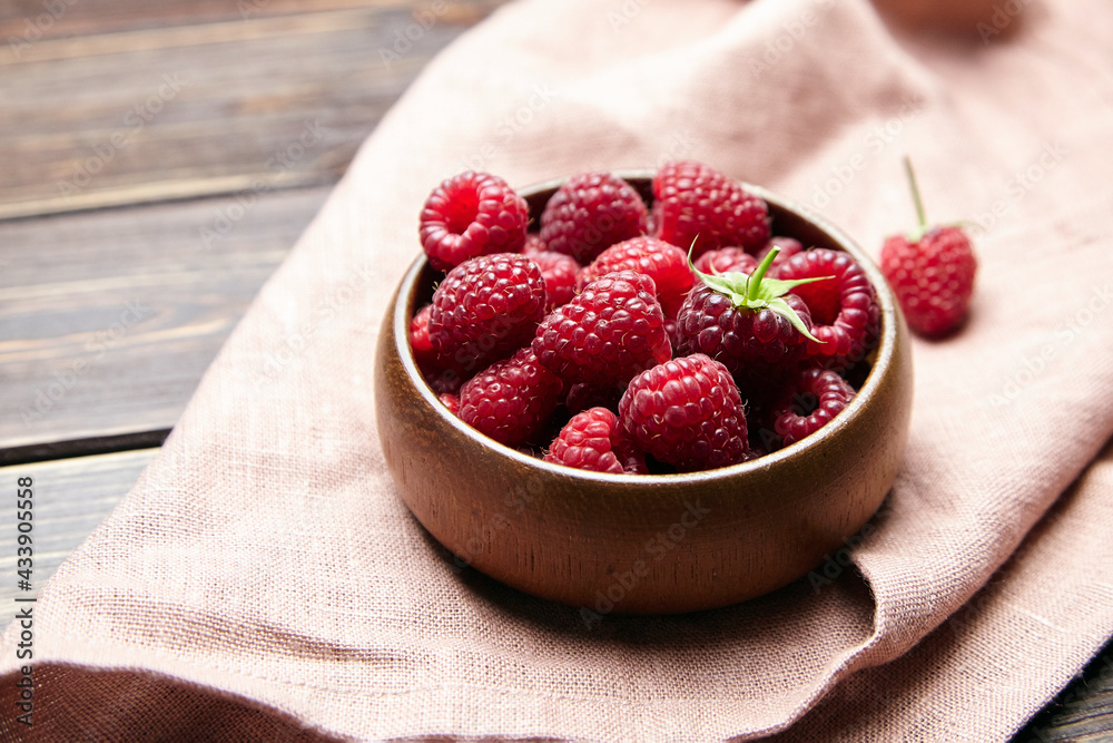 Fresh raspberries in wooden bowl on brown table. Red ripe raspberries, sweet berries Fresh raspberries in wooden bowl on brown table. Red ripe raspberries, sweet berries