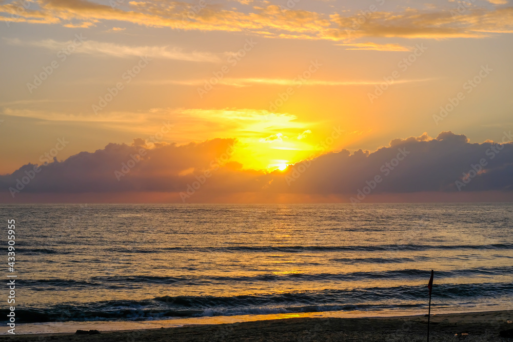 Fototapeta premium Sunset evening sea are disappearing into the clouds, gloomy atmosphere and cause an orange glow shone with reflected wave of the sea, a beautiful sparkling.