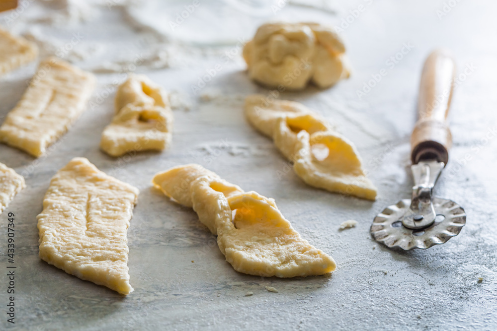 Cutting homemade angel wings from fresh dough. Homemade pastries. Cutting homemade angel wings from fresh dough. Homemade pastries.
