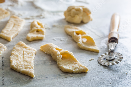 Cutting homemade angel wings from fresh dough. Homemade pastries.