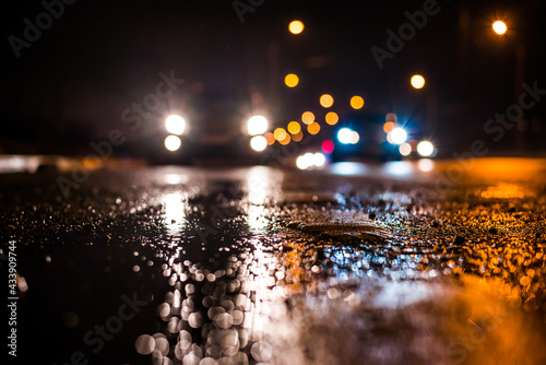 Rainy night in the big city  the cars traveling towards the headlights illuminate the road. Close up view from the level of the dividing line