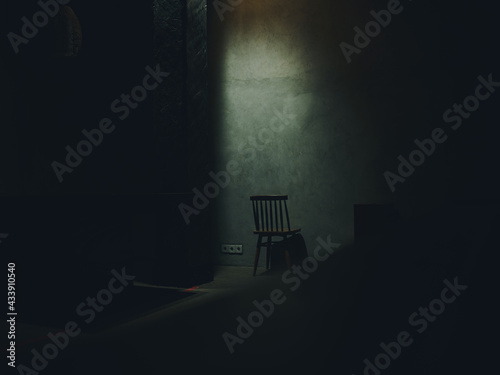 Papier peint one chair stands in the middle of a dark room silhouette of a falling light inte