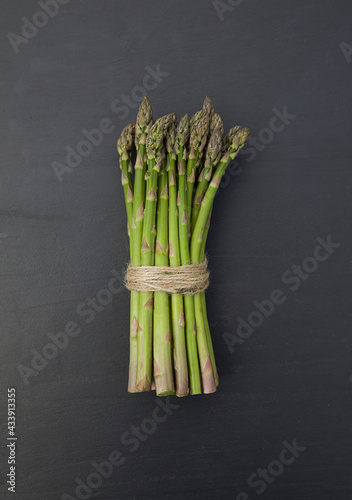 Fresh green asparagus on black background. Top view.