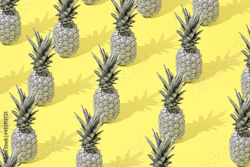 Creative summer pattern background with gray pineapple on a yellow background. Minimal style. Creative summer or food concept.