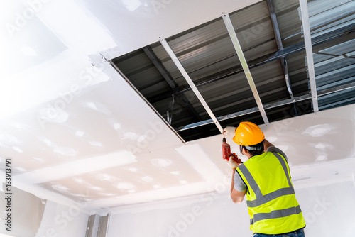 Construction workers are installing the ceiling house in the building under construction, Ceiling installation ideas photo