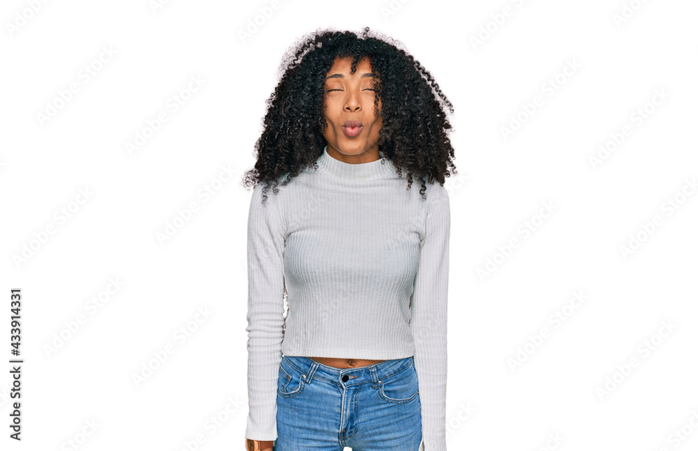 Young african american girl wearing casual clothes making fish face with lips, crazy and comical gesture. funny expression. Young african american girl wearing casual clothes making fish face with lips, crazy and comical gesture. funny expression.