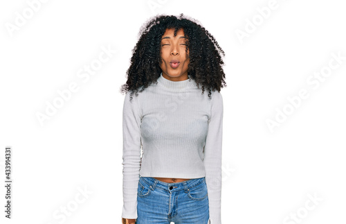 Young african american girl wearing casual clothes making fish face with lips, crazy and comical gesture. funny expression.