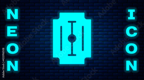 Glowing neon Blade razor icon isolated on brick wall background. Vector